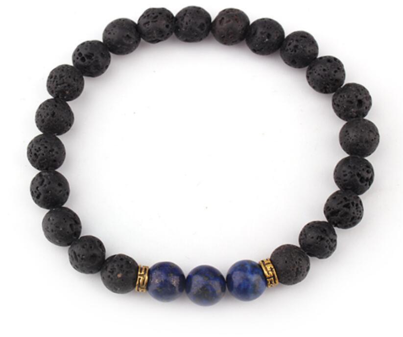 Lava stone and lapis lazuli bead bracelet with gold accents, displayed on a white background, showcasing its earthy and bold design.