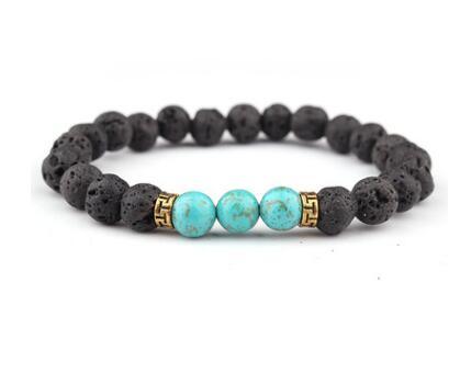 Lava stone and turquoise bead bracelet with gold accents, displayed on a white background, showcasing its natural and earthy design.