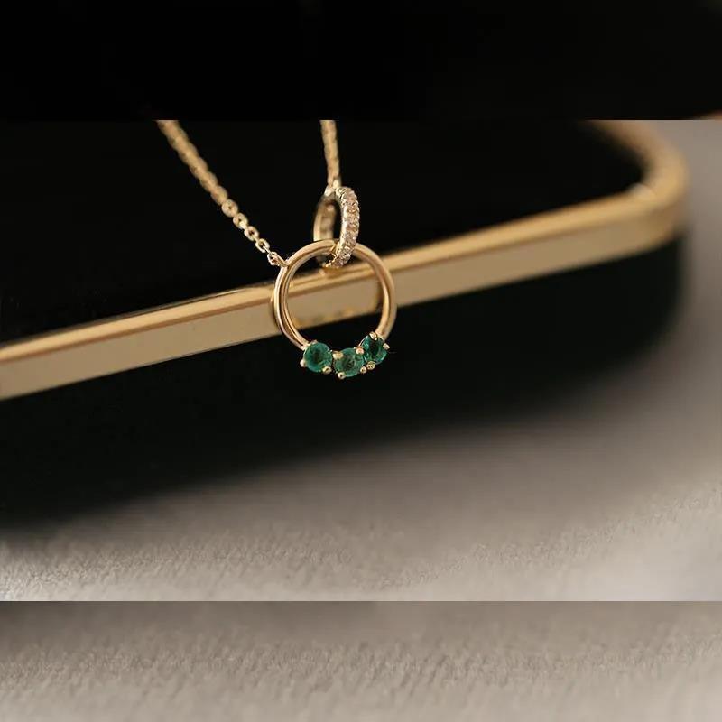 Minimalist Swarovski crystal necklace in gold, featuring overlapping rings with radiant green accents for a touch of modern elegance.