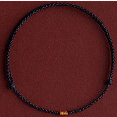 Minimalist black cord bracelet with a gold accent, perfect for a subtle yet stylish look.