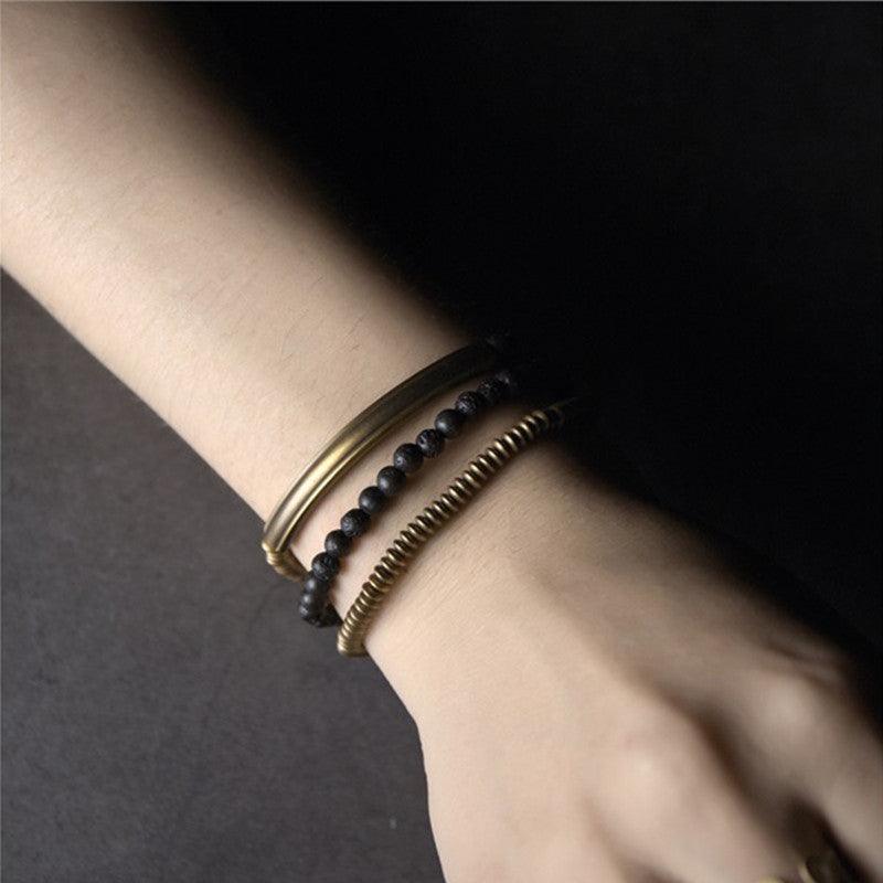 Minimalist black obsidian and brass bracelet set, perfect for a modern, understated look.