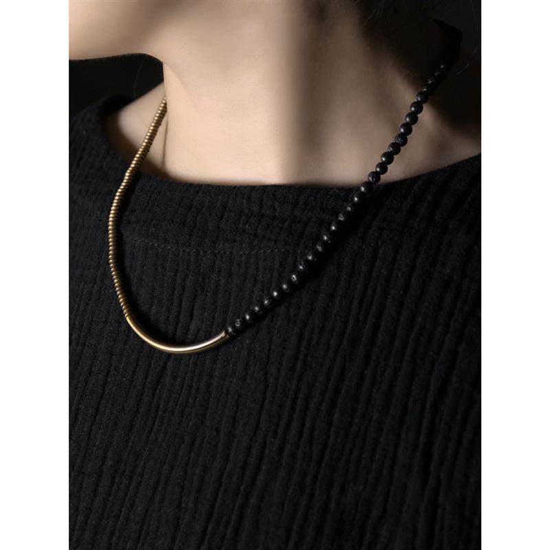 Minimalist black obsidian and brass necklace, perfect for a modern, elegant look.