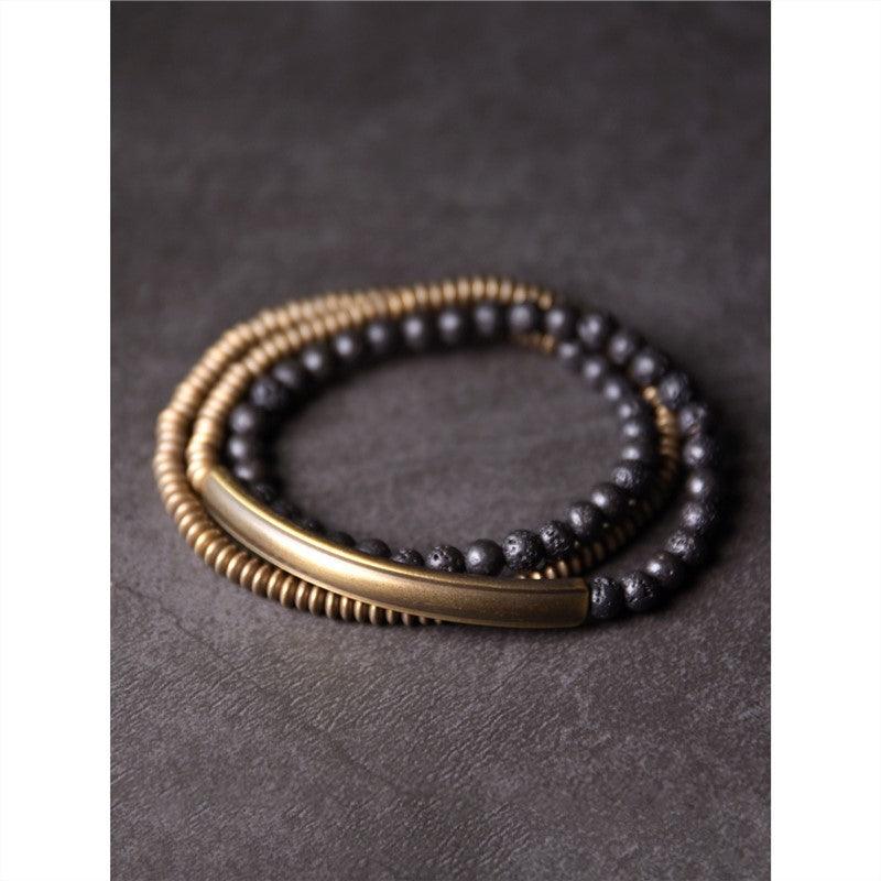 Minimalist black obsidian bracelet with brass accents, symbolizing strength and stability.