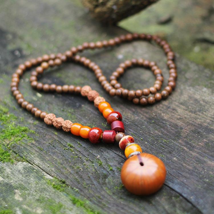 Natural wood and seed bead mala necklace with earthy tones, perfect for meditation and grounding, featuring amber, Rudraksha, and sandalwood beads.