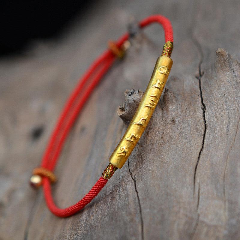 Side view of the bracelet, highlighting the durability of the red rope and the secure connection with the golden mantra bar.
