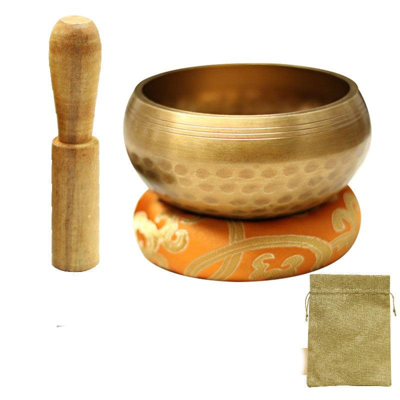 Singing bowl set with a decorative cushion, used in mindfulness meditation to create a tranquil atmosphere and deepen focus.