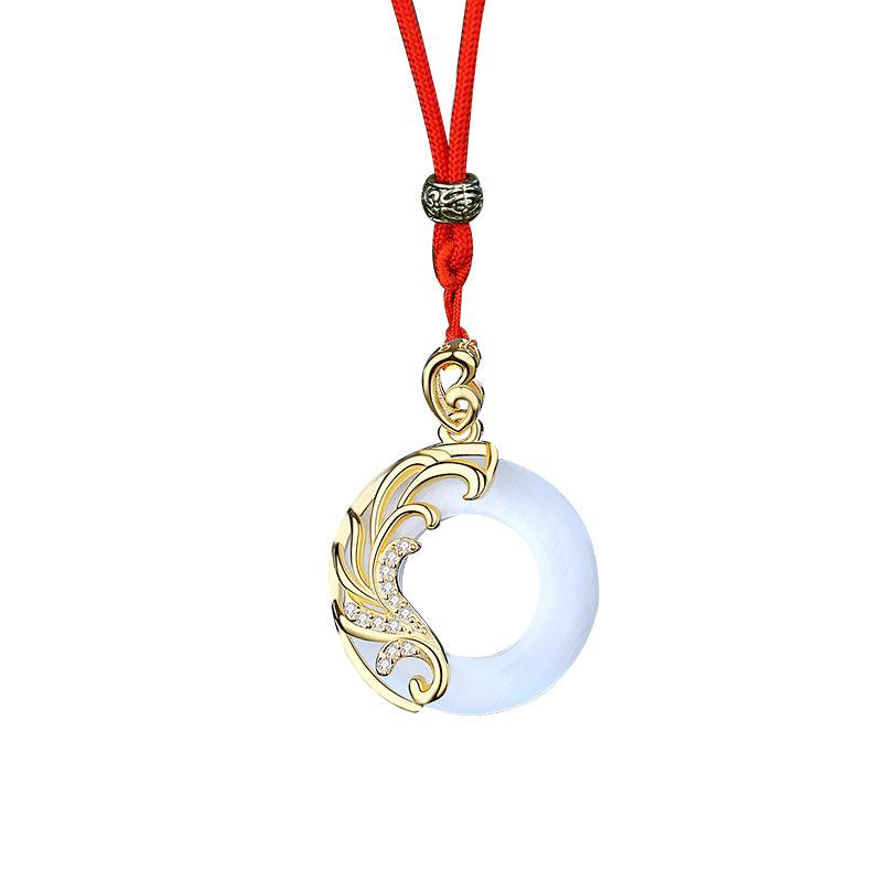 The pendant is crafted from white jade and features gold floral accents and sparkling details on a delicate gold chain.