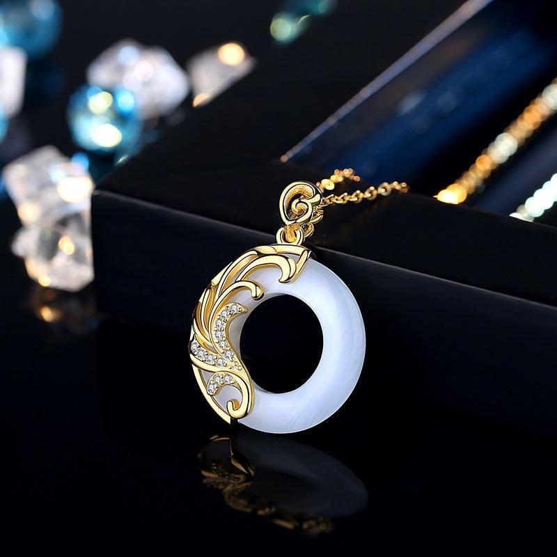 The pendant is crafted from white jade and features gold floral accents and sparkling details on a delicate gold chain.