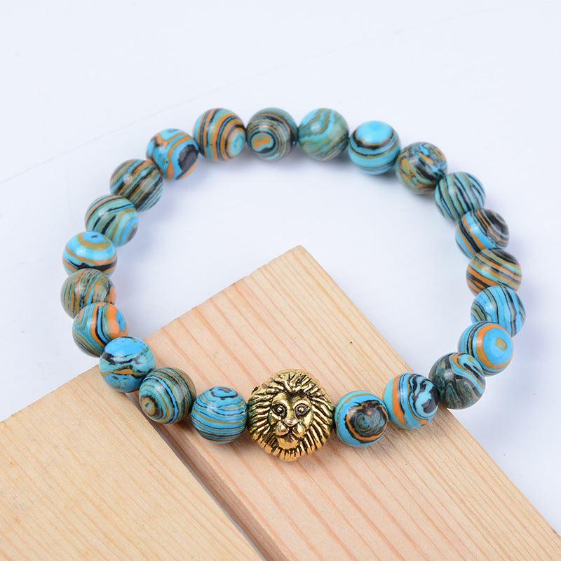 Turquoise and orange swirled gemstone bracelet with gold lion charm for strength and courage.