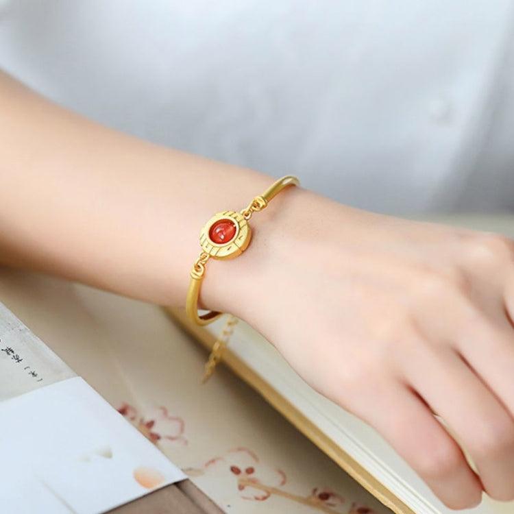 Worn view of the gold bracelet with red agate, adding elegance and warmth to any outfit.