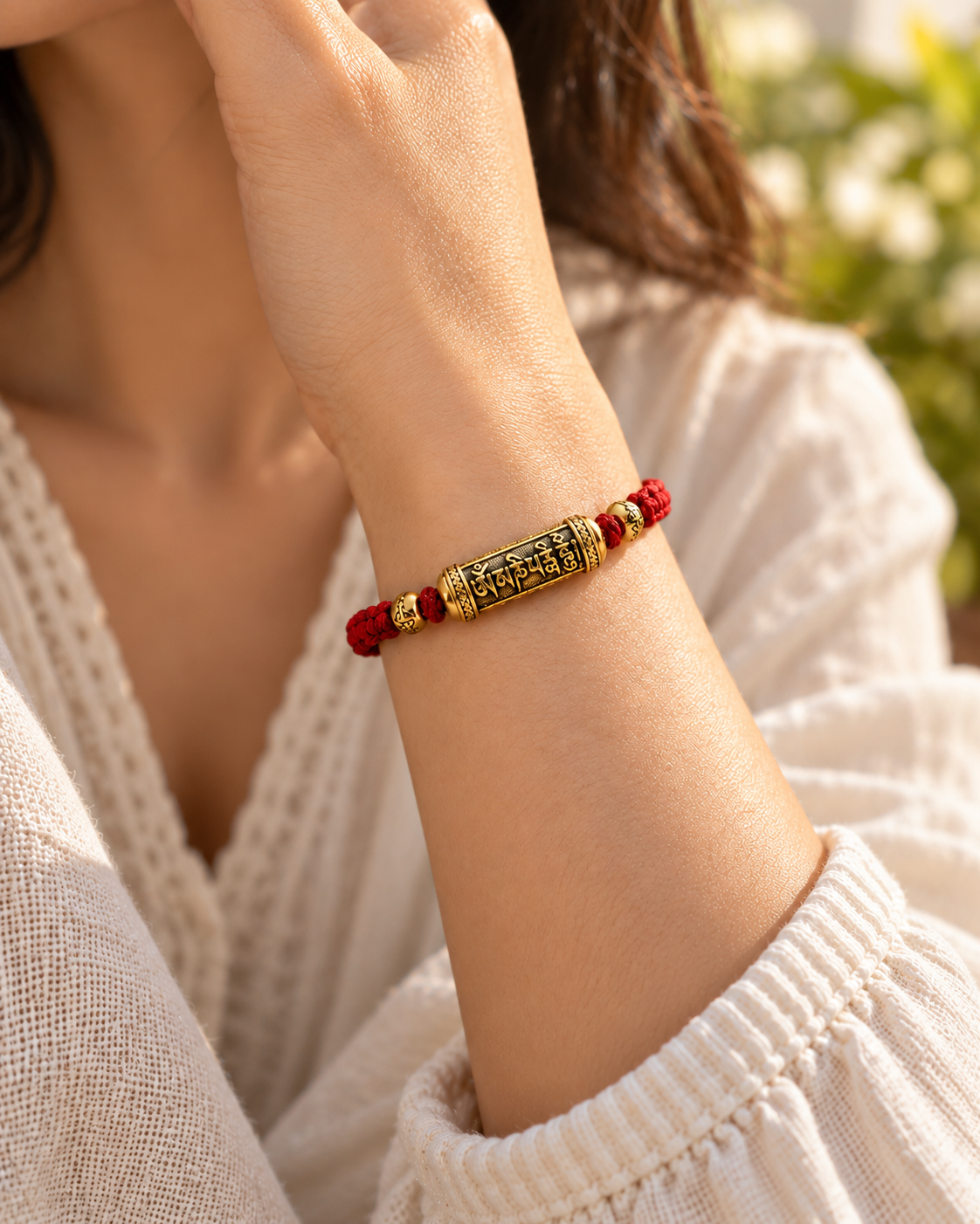 AI-assisted lifestyle image showing the gold-tone Om Mani Padme Hum red string bracelet worn on a wrist